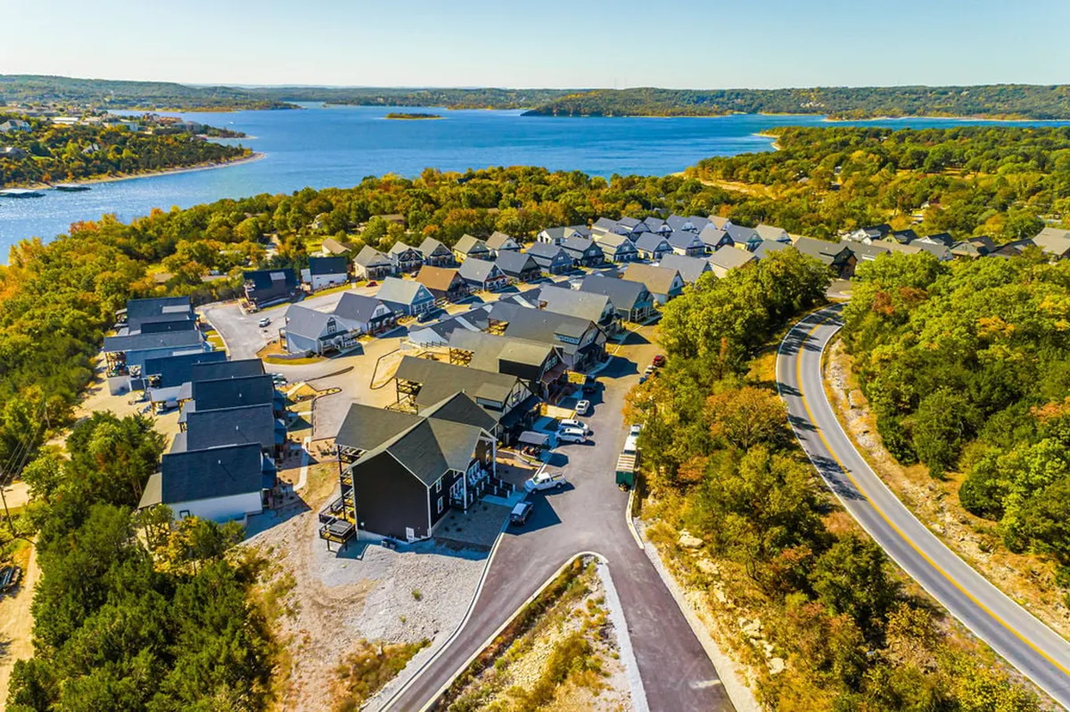 An aerial perspective highlighting the neighborhood's layout in relation to the lake, with walking paths, roadways, trees, and lakeside houses. It conveys both the convenience of access and the vibrant community atmosphere along the lakefront.