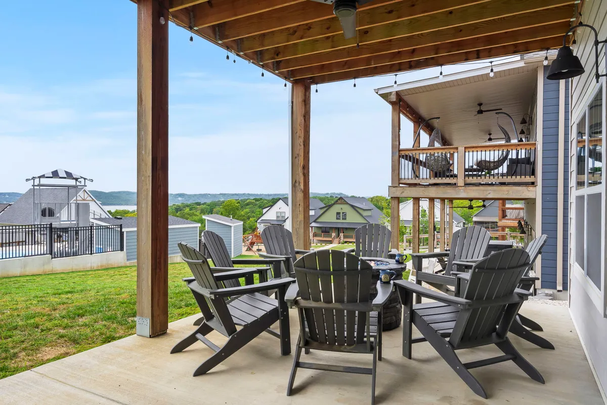 This photo features adirondack chairs and an outdoor table set on a patio overlooking the hills, providing a relaxing and accessible space for group gatherings. The flat, open setting and wide pathways make this outdoor area suitable for guests of all abilities to enjoy sunset views and group activities.